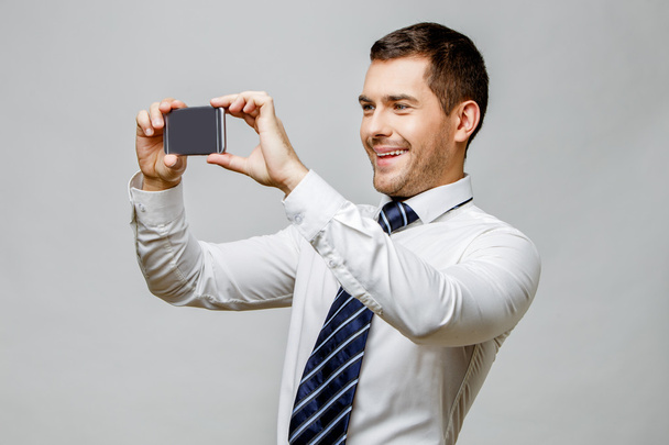 Handsome stylish businessman on grey background - Valokuva, kuva