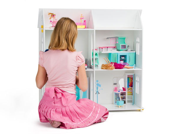 Little girl is playing with the dollhouse full of dolls and furn - Photo, Image