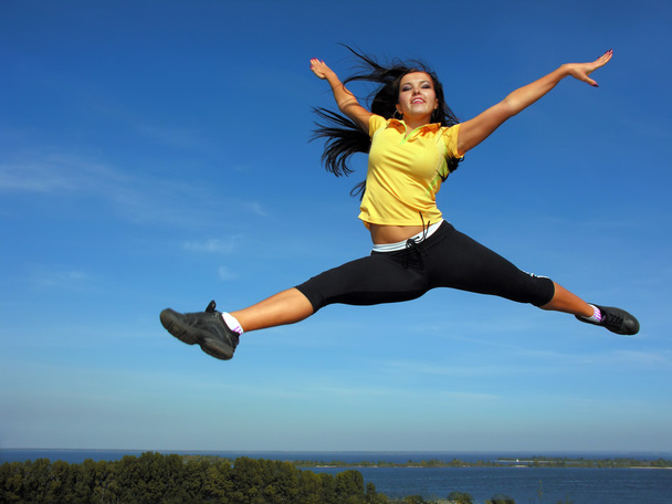 atlética joven mujer volando en el cielo
 - Foto, Imagen