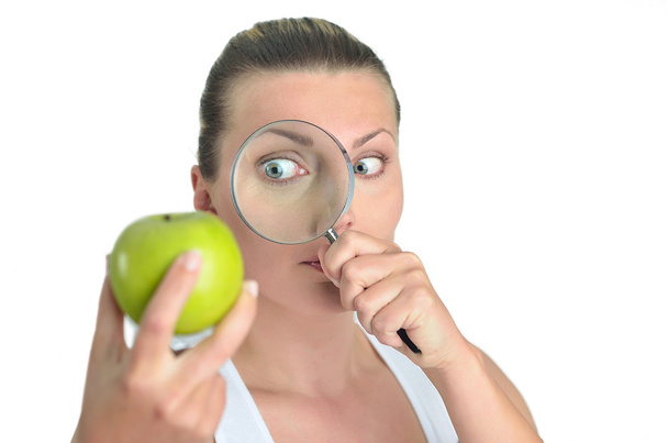υγιή Μπλόντι ευτυχισμένη γυναίκα βλέποντας πράσινο μήλο με ένα magnifyin - Φωτογραφία, εικόνα