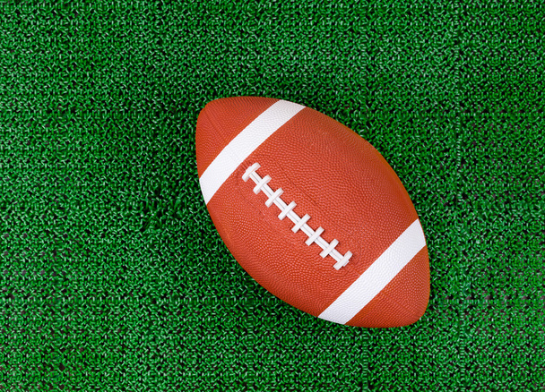 緑の芝生を人工芝のフィールドにアメリカン フットボール  - 写真・画像