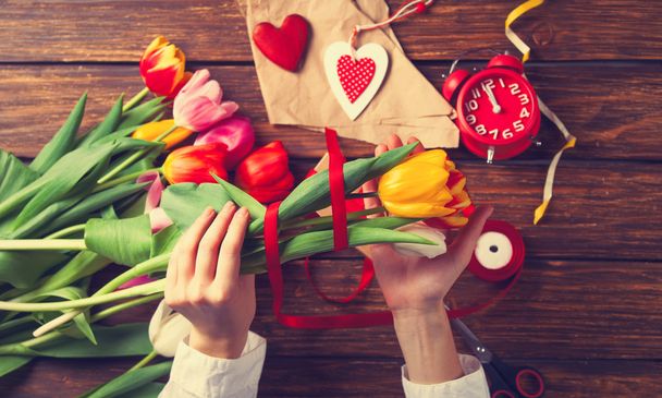 Female hands are holding a tulip flowers - Zdjęcie, obraz