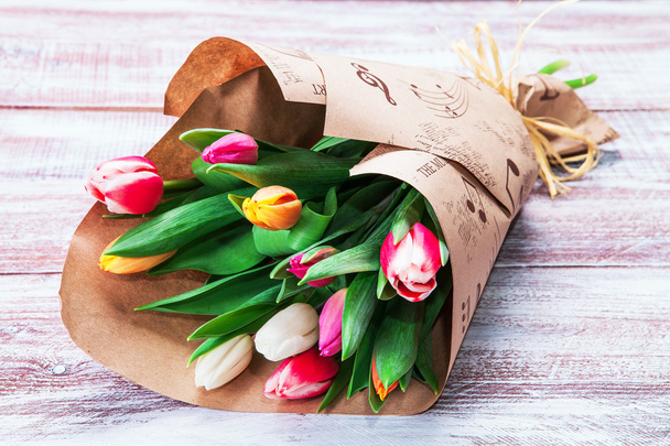 bouquet of tulips is wrapped in a paper - Foto, Imagen