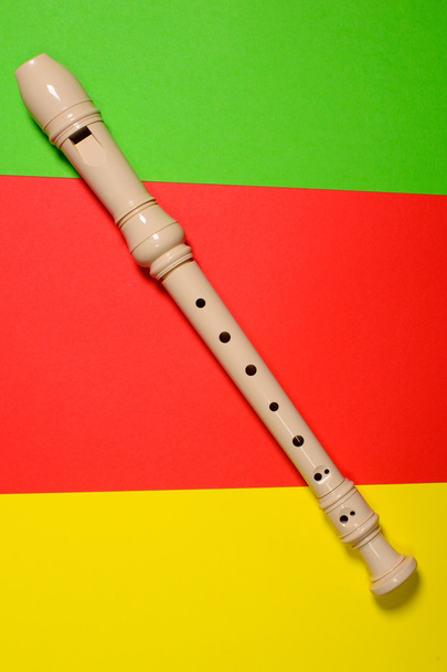 Flauta blanca de plástico aislada sobre fondo de color
 - Foto, imagen