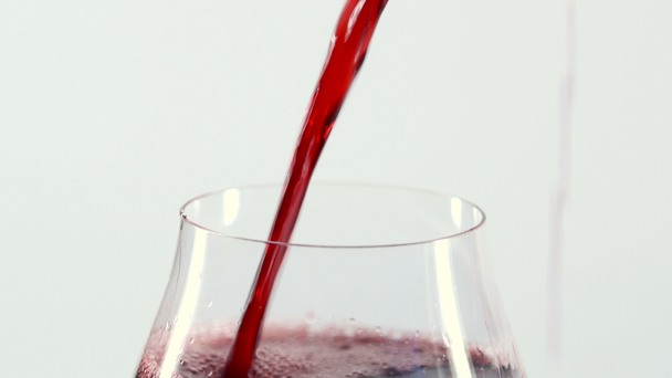 Red wine pouring into a glass, white, closeup - Footage, Video