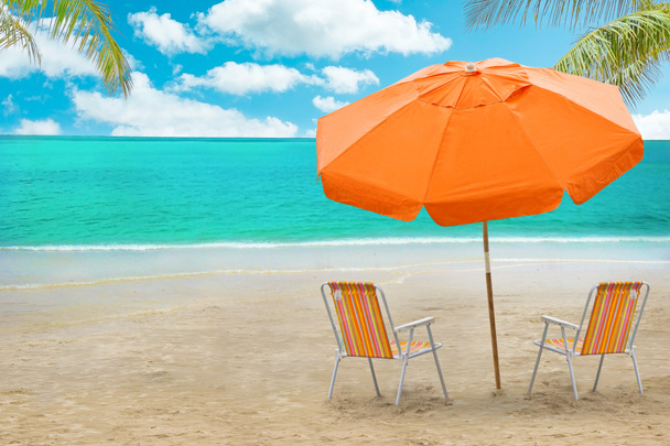 Chaise lounge en parasol op strand - Foto, afbeelding