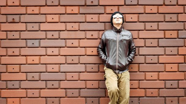 Asijského muže v hnědé sako se opírá o zeď - Fotografie, Obrázek