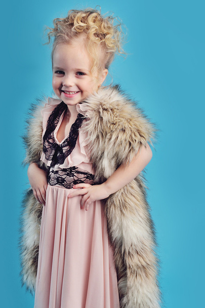 little girl in a long dress and a fur coat - Fotó, kép