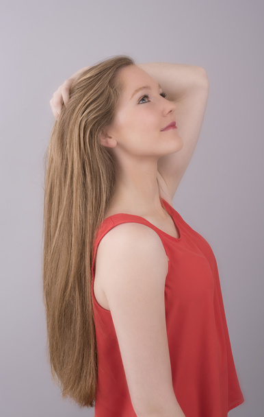 Teenager s dlouhými vlasy a na sobě červený top - Fotografie, Obrázek
