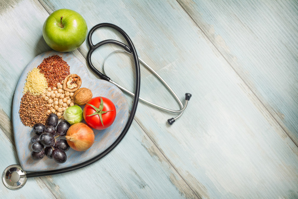Healthy lifestyle and healthcare concept with food, heart and stethoscope - Фото, зображення