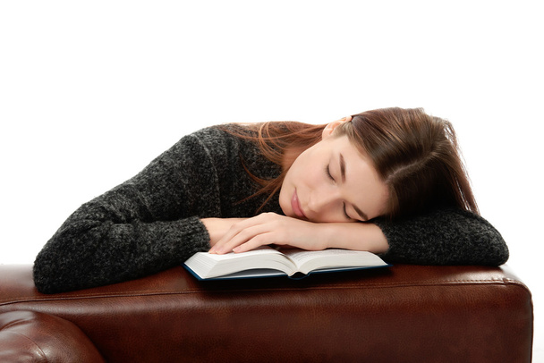 Young woman with book leaning on leather furniture - Foto, Imagen
