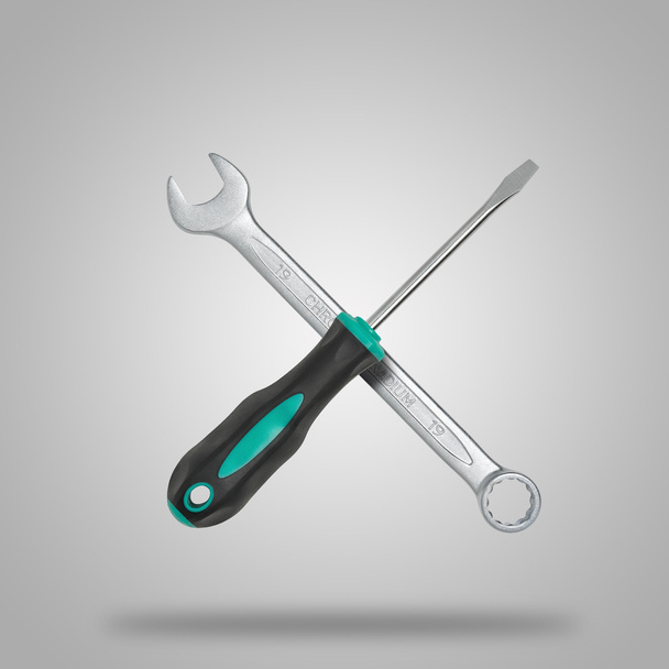 Crossed wrench and screwdriver on gray background like icon - Foto, imagen
