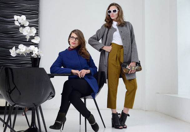 Girls in studio posing at coats - Foto, Imagen