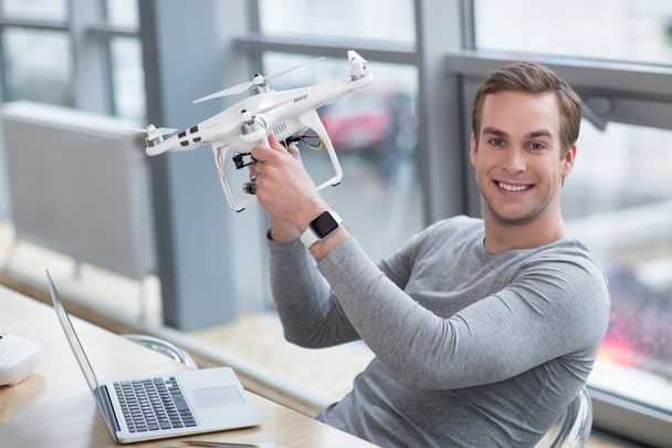 Handsome young worker is projecting a quadrocopter - Foto, Imagen