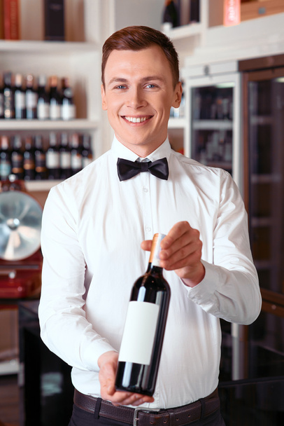 Professional sommelier holding wine bottle - 写真・画像