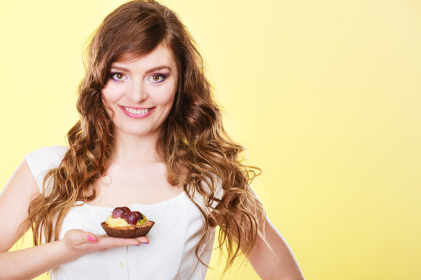 Smiling cute woman holds fruit cake in hand - Photo, Image
