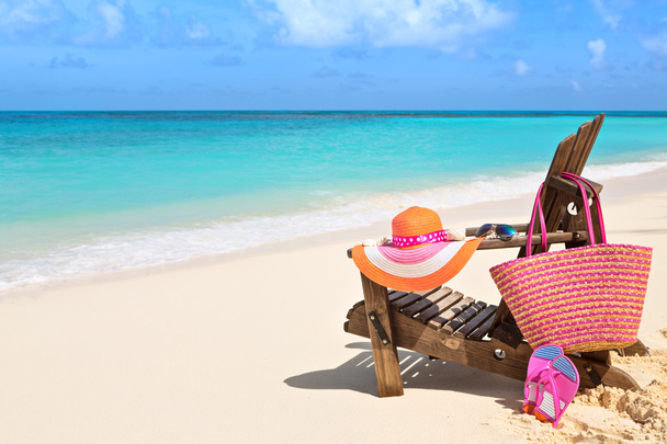 Židle s vakem, klobouk, žabky a sluneční brýle na slunné pláži, t - Fotografie, Obrázek