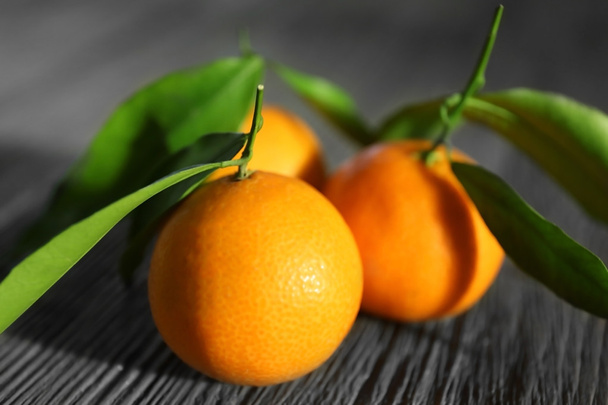 Fresh tangerines with leaves on wooden table, closeup - Φωτογραφία, εικόνα