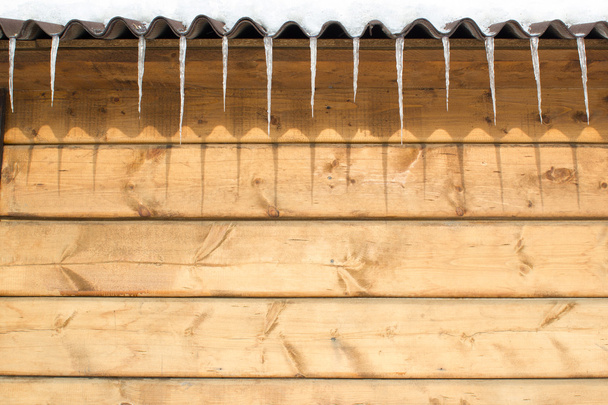 Ghiaccioli sul tetto di una casa di legno
 - Foto, immagini