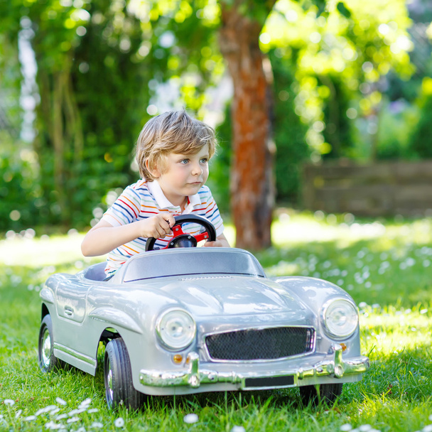 Kid boy driving with big toy car outdoors - Photo, Image