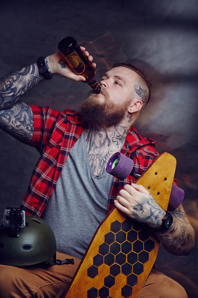 Szakállas tetovált ember iszik sört - Fotó, kép