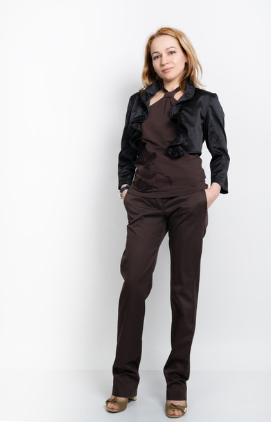 Beautiful young leggy blonde in a  brown top, black jacket and pants posing - Fotografie, Obrázek