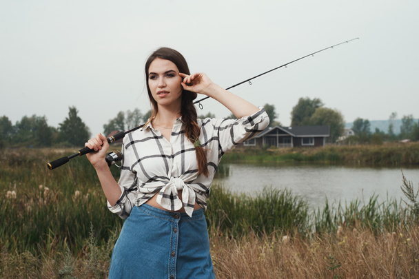  kraju kobieta stojąca przed staw na ranczo z ryb pręt  - Zdjęcie, obraz