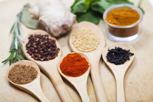 Spices on wooden spoons - Foto, afbeelding