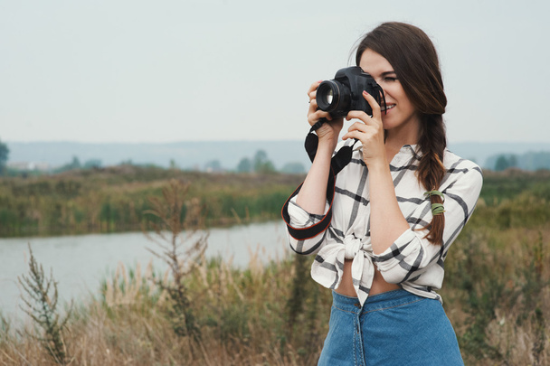 pretty playful country lady posing with camera against pond - Foto, Bild