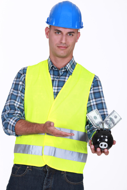 Manual worker holding piggy-bank - Фото, изображение