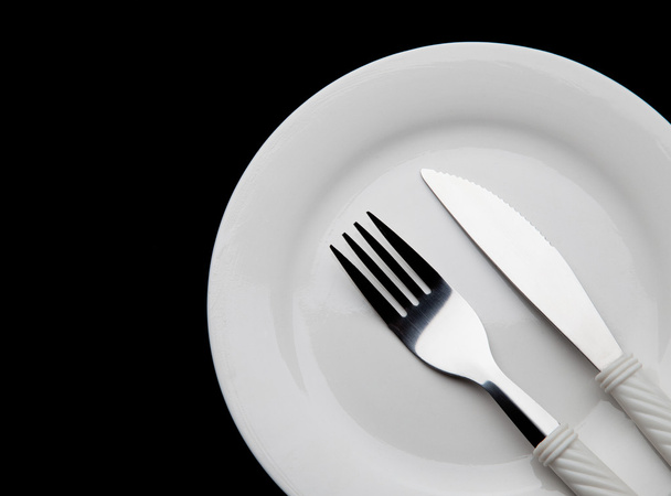 Part of Knife fork and plate on a black background - Foto, imagen