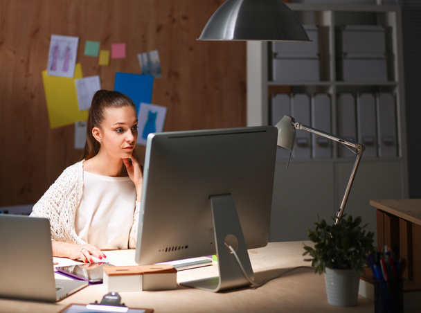 Young woman working in office, sitting at desk - Φωτογραφία, εικόνα