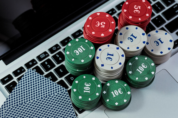 Vista de fichas de casino, tarjetas en el ordenador portátil para jugar en línea
. - Foto, imagen