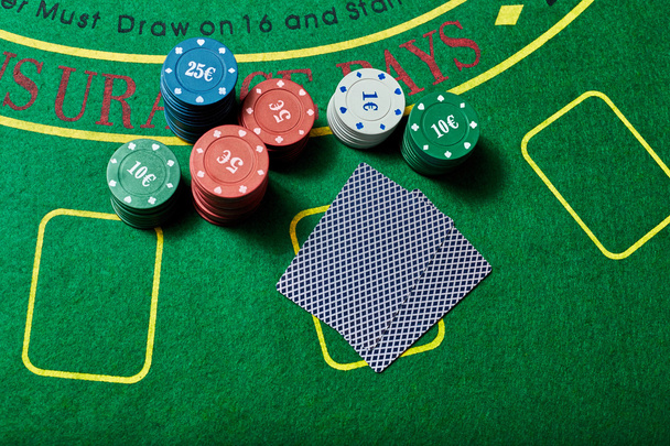 фішки казино і колода карт, що лежать на столі казино
 - Фото, зображення