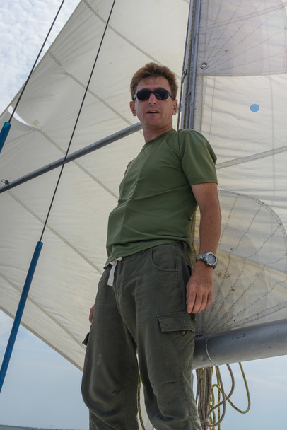 A successful man standing on a yacht under sail. - Foto, afbeelding