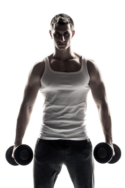 白い背景に隔離されたダンベルを持つハンサムな筋肉の男 - 写真・画像