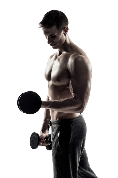 Homme athlétique montrant le corps musculaire et faire des exercices avec haltères
 - Photo, image