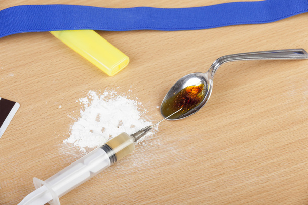Heroína cocida en una cuchara y una jeringa cargada
 - Foto, imagen