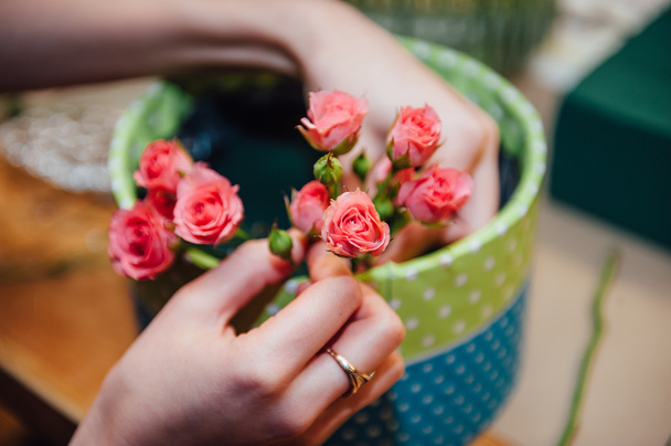 florist makes a basket with different flowers - Foto, imagen