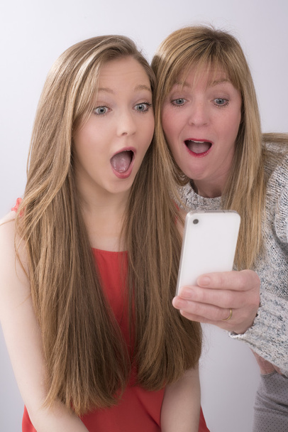 Madre e hija adolescente usando un teléfono móvil
 - Foto, Imagen