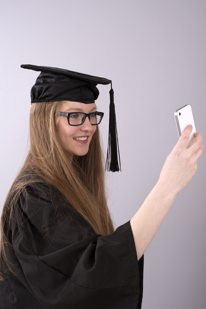 Diplômé prenant une photo selfie à l'aide d'un téléphone mobile
 - Photo, image