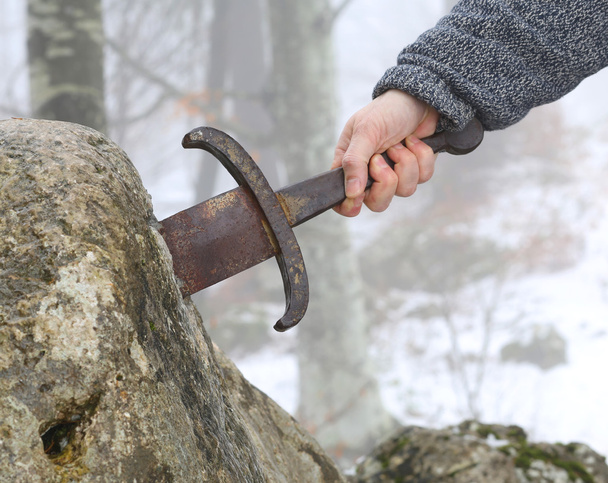 Cavaleiro tenta remover a espada Excalibur na pedra
 - Foto, Imagem