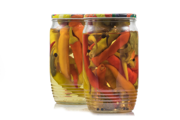 Két fennmaradt a savanyított chili paprika üvegedények a fehér fonákkal - Fotó, kép