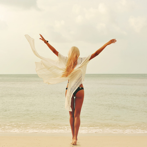 幸せな女がビーチで自然を満喫します。腕を大きく開くと、ヒリ - 写真・画像
