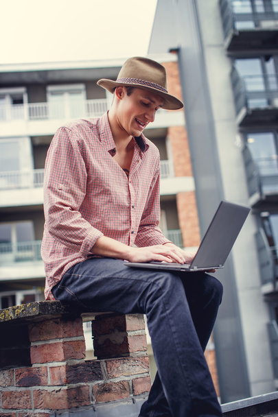 Lässiger Mann mit Hut und Laptop - Foto, Bild
