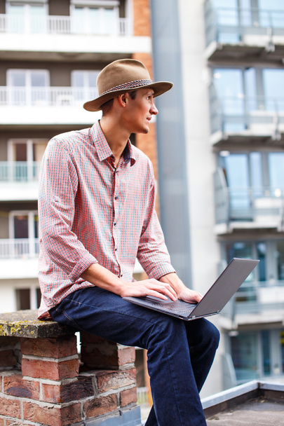 Lässiger Mann mit Hut und Laptop - Foto, Bild