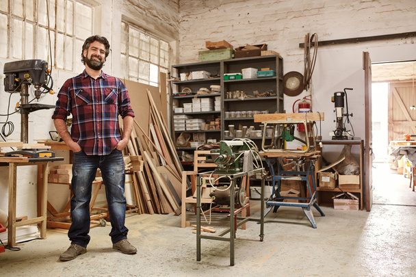 craftsman standing in workshop with heavy-duty machinery - Фото, зображення
