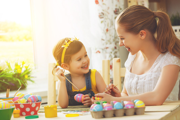 happy family mother and child girl paints eggs for Easter - 写真・画像