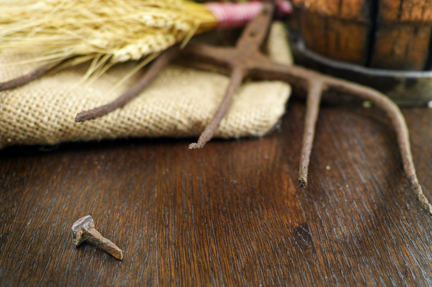 Antieke pitchfork en vergeet ijzer spijker op jute closeup - Foto, afbeelding