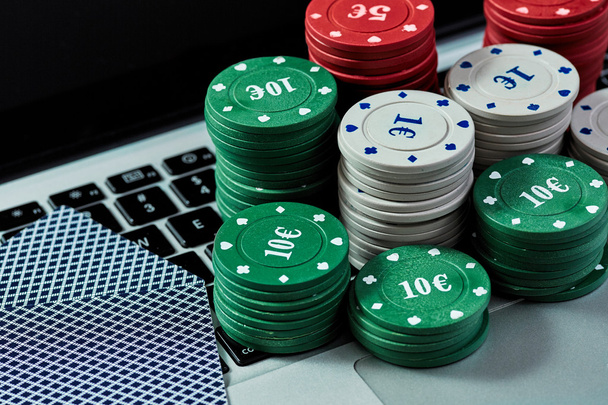 Vista de fichas de casino, tarjetas en el ordenador portátil para jugar en línea
. - Foto, Imagen